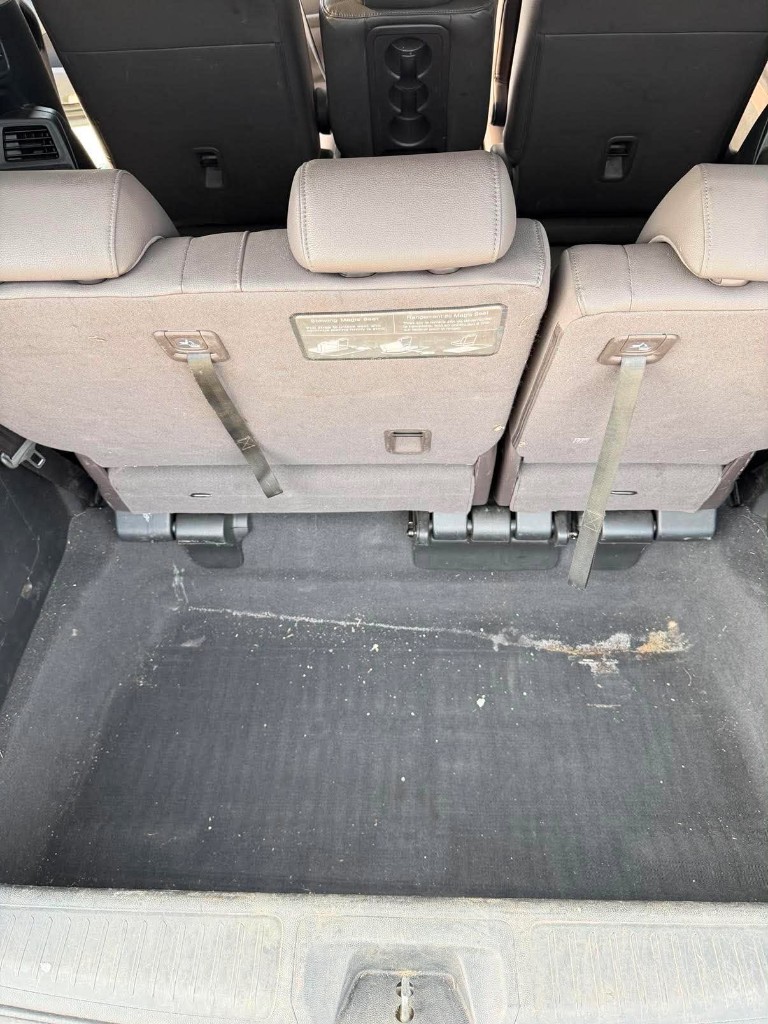 Cargo area before detailing — crumbs and stains on the carpet